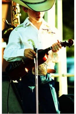 Colby Sheppard performing on fiddle in a white cowboy hat